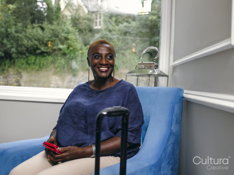Smiling woman sitting in armchair in hotel lobby