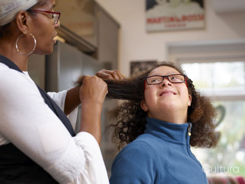 Mother doing hair of daughter with Down Syndrome