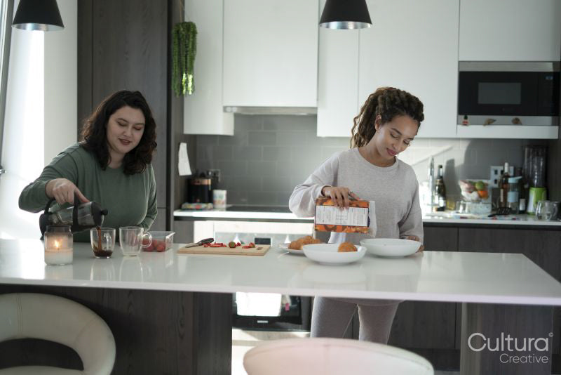 Two women preparing meal in kitchen