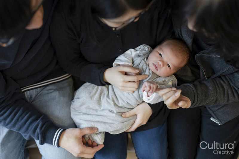Two generation family with baby girl sitting on sofa