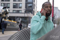 South Yorkshire, Man in green hooded shirt talking on phone in city