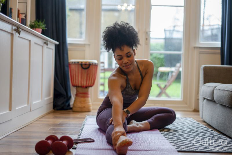 Young woman stretching at home