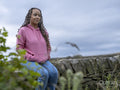 Teenage girl sitting on stone wall