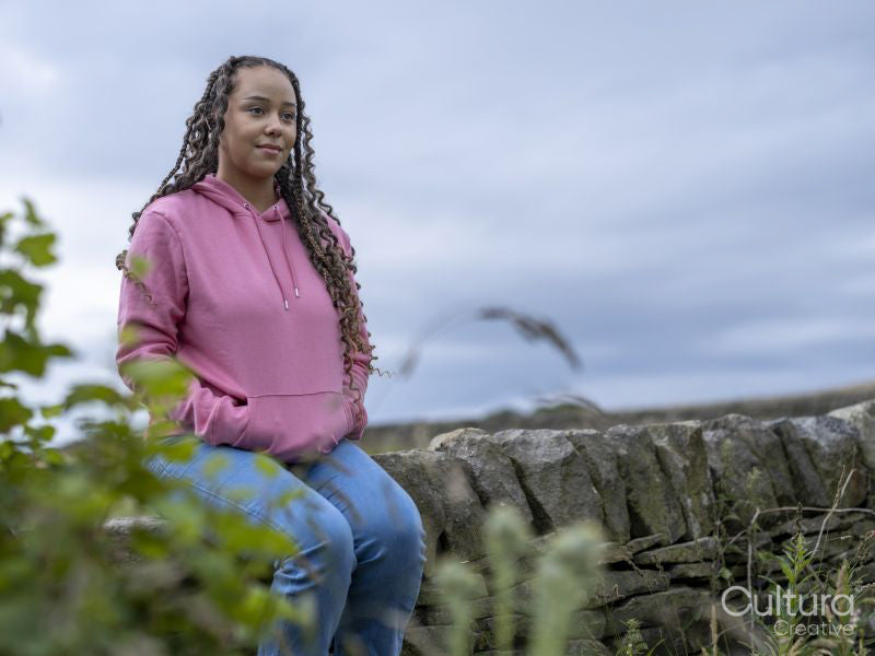 Teenage girl sitting on stone wall