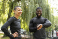 Smiling athletic man and woman standing in park
