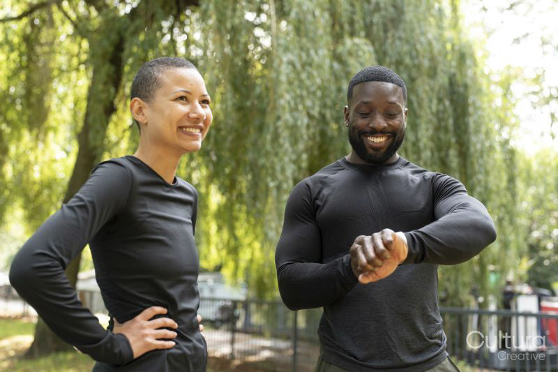 Smiling athletic man and woman standing in park