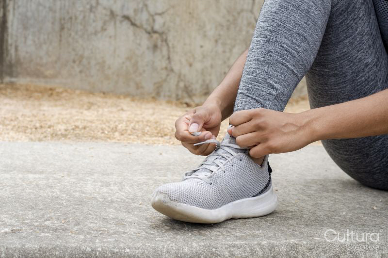Close up of woman tying laces in sports shoes before training