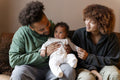 Parents sitting on sofa with baby daughter