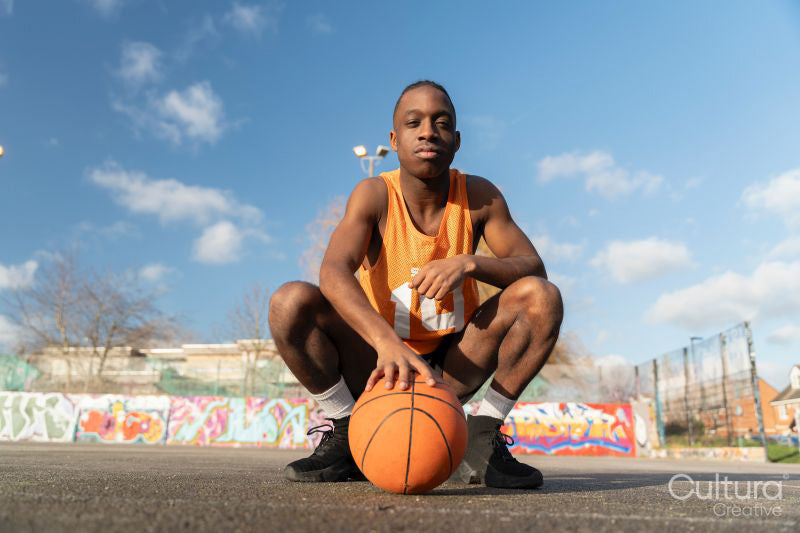 Portrait of basketball player with ball on outdoor court