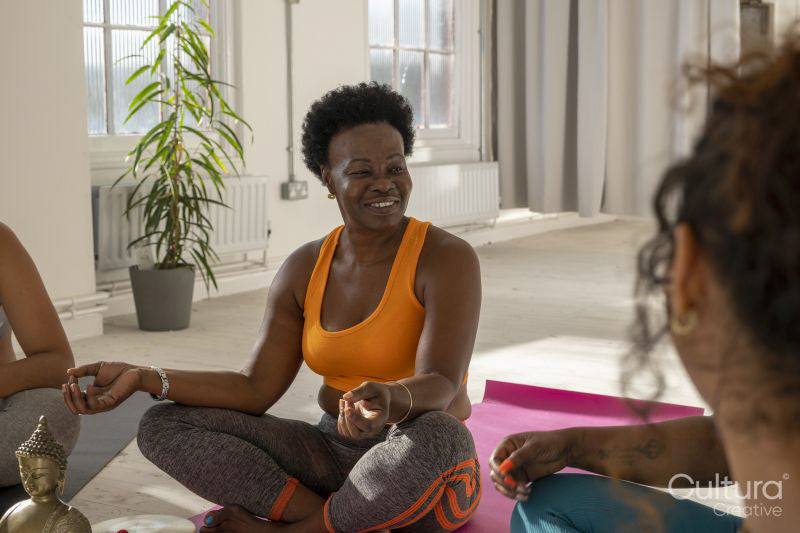 Smiling women sitting in yoga studio