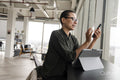 Woman using digital tablet and phone in office