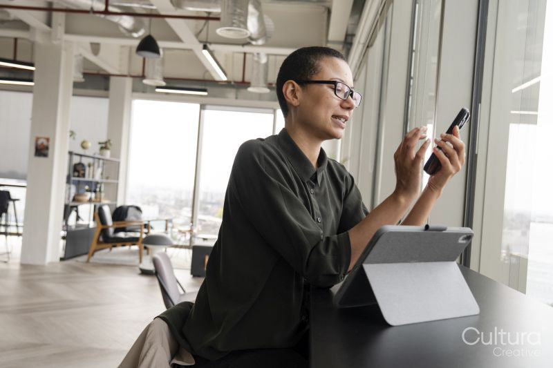 Woman using digital tablet and phone in office