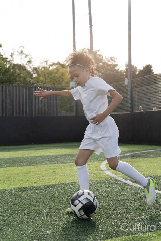 Girl playing soccer on soccer field