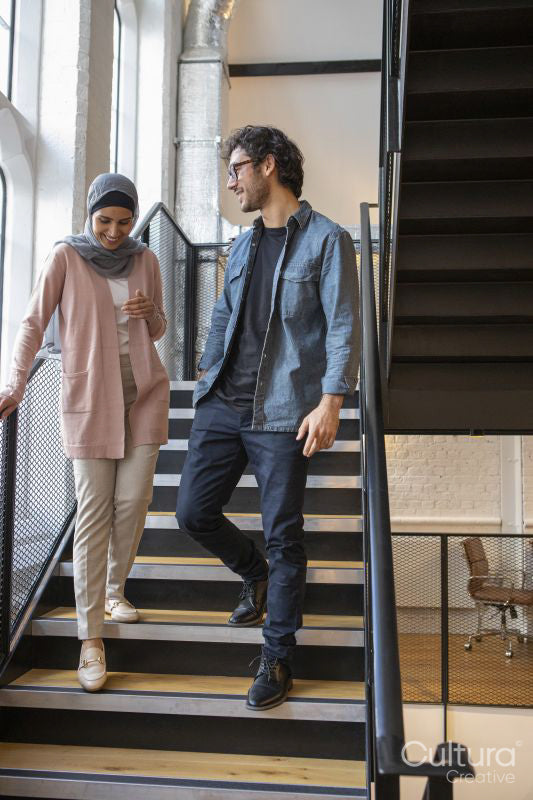 Woman wearing headscarf and man talking on steps