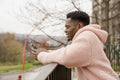 Smiling young man using phone outdoors
