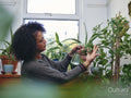 Woman tending plants at home