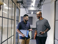 Two men talking in office hallway
