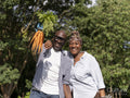 Smiling mature couple collecting carrots in allotment