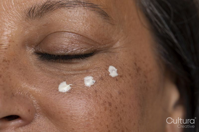 Close-up of woman with dots of eye cream
