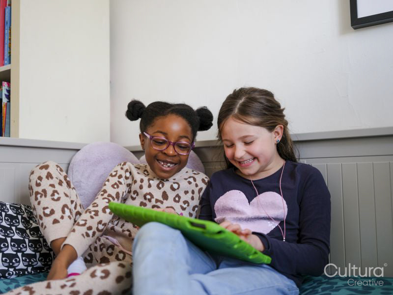 Girl friends using digital tablet at home