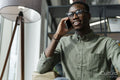 Young man with smartphone sitting in office lounge