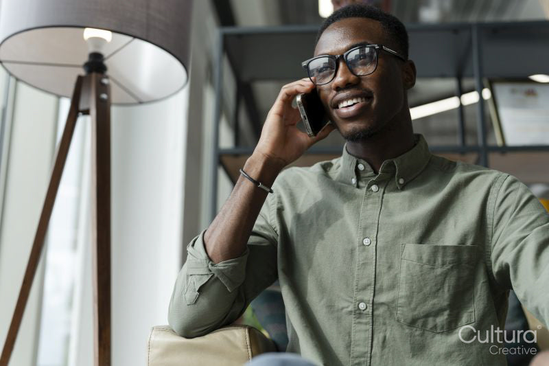 Young man with smartphone sitting in office lounge