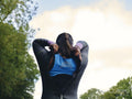 Rear view of woman putting on wetsuit
