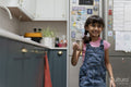 Little girl holding mug in kitchen