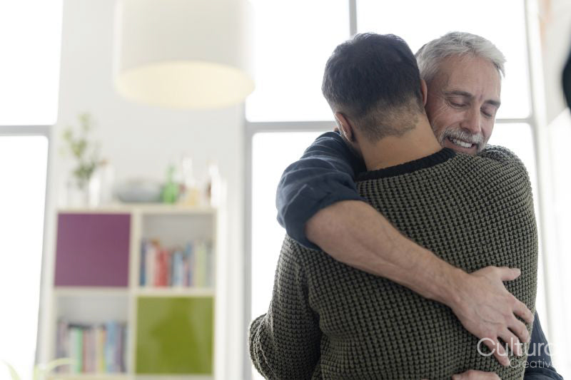 Male couple hugging at home