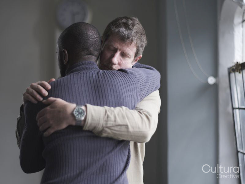 Men hugging in therapy session
