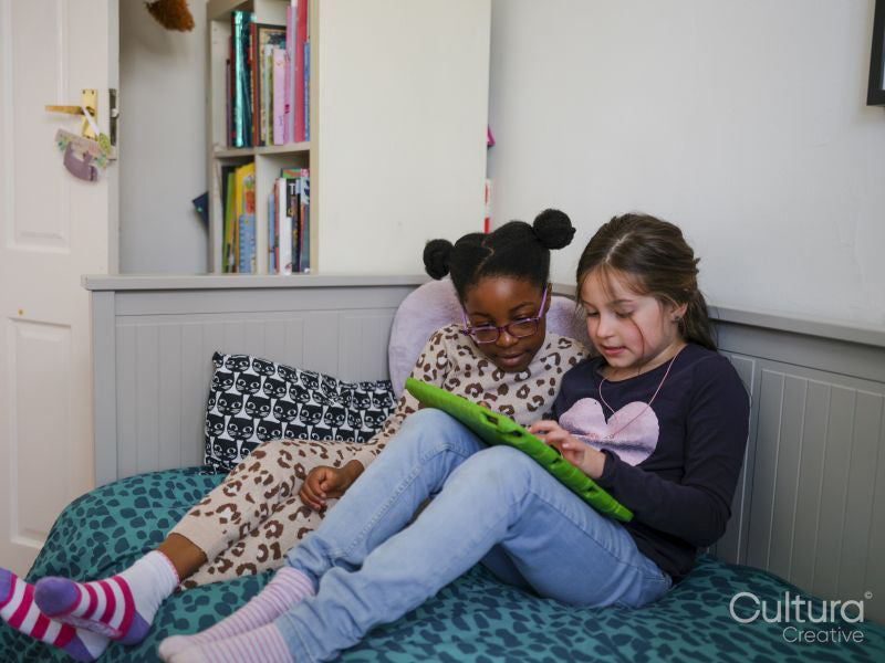 Girl friends using digital tablet at home