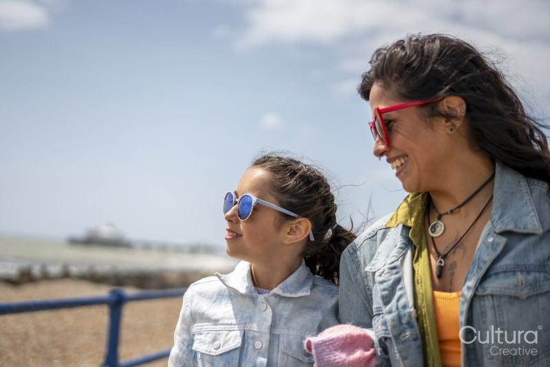 Mother and daughter walking along beach