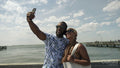 Smiling couple taking selfie on pier