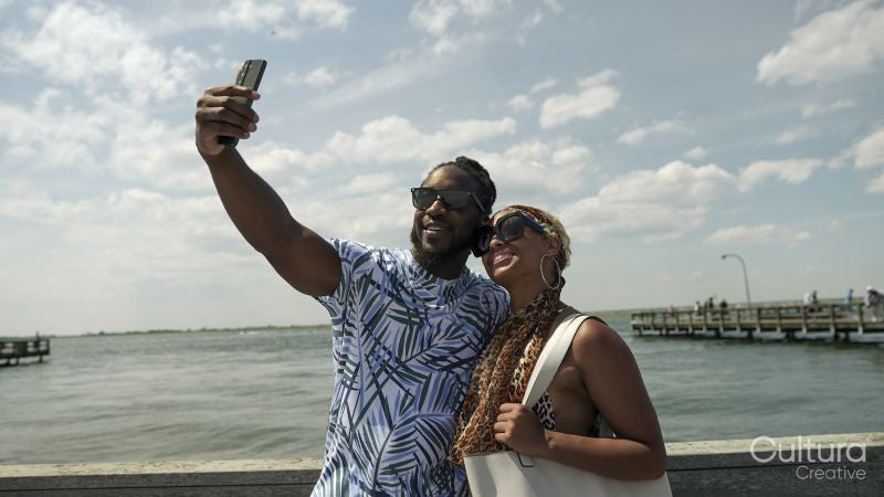 Smiling couple taking selfie on pier