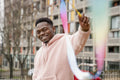 Portrait of smiling young man holding colorful ribbon