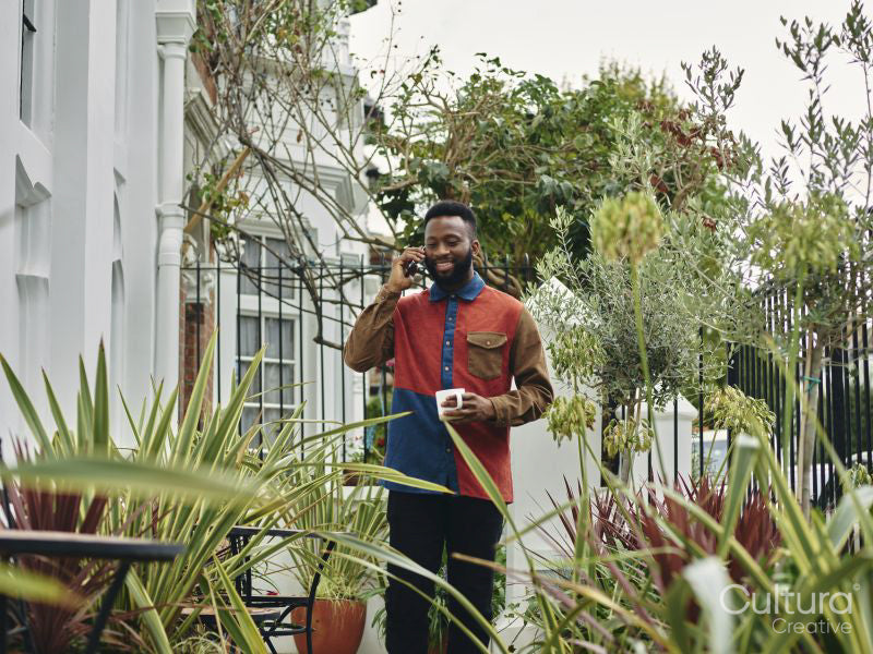 Smiling ma talking on smart phone in garden