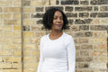 Portrait of thoughtful woman standing by brick wall