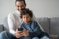 Father and son using smart phone at home