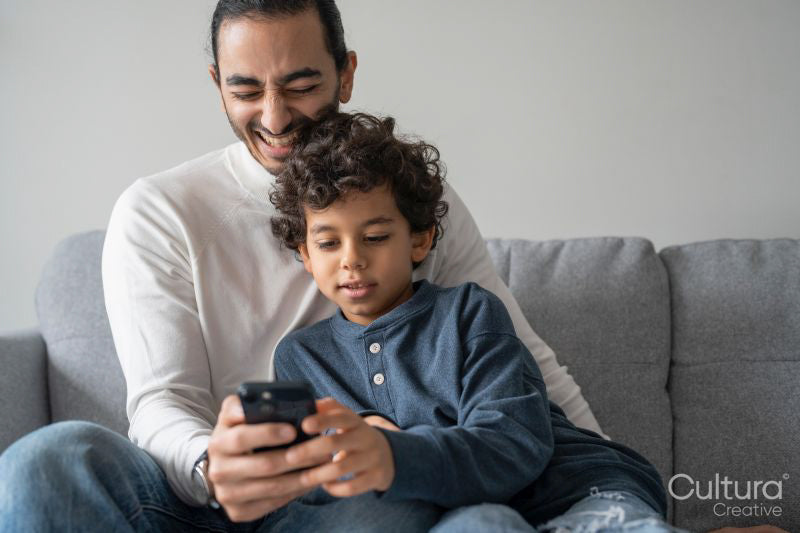 Father and son using smart phone at home