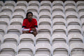 Portrait of athletic woman sitting on chair at empty stadium