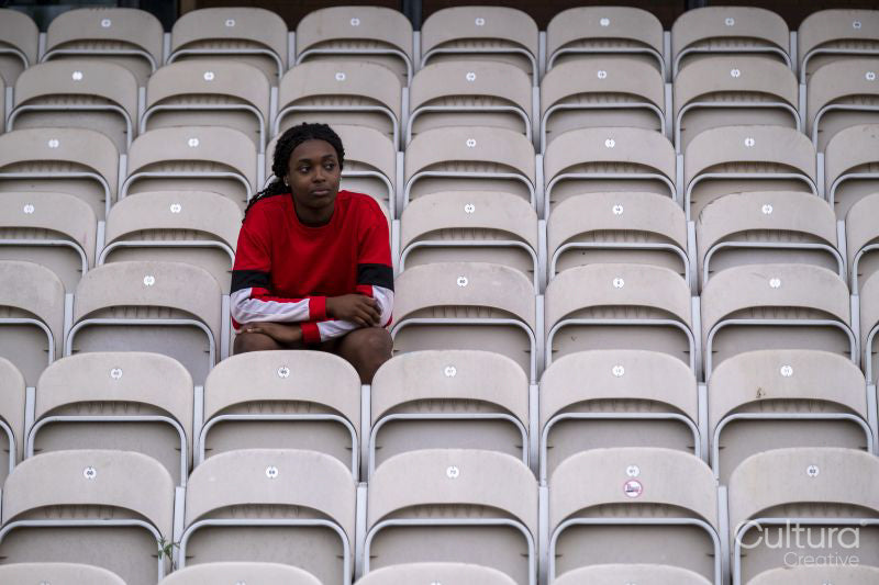 Portrait of athletic woman sitting on chair at empty stadium
