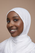 Studio portrait of smiling young woman wearing white hijab