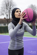 Woman in hijab playing basketball
