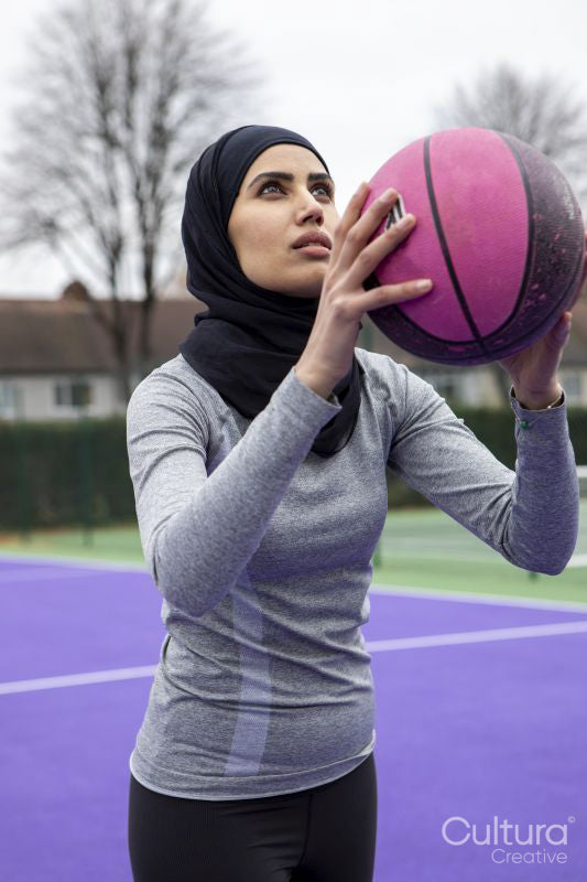 Woman in hijab playing basketball