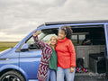 Female couple taking selfie in front of van