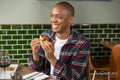 Smiling man enjoying Me,ican food at restaurant table
