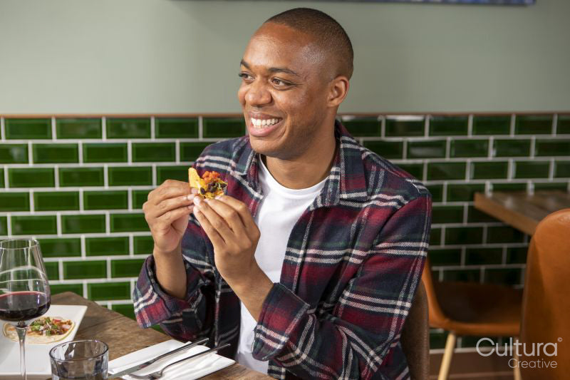 Smiling man enjoying Me,ican food at restaurant table