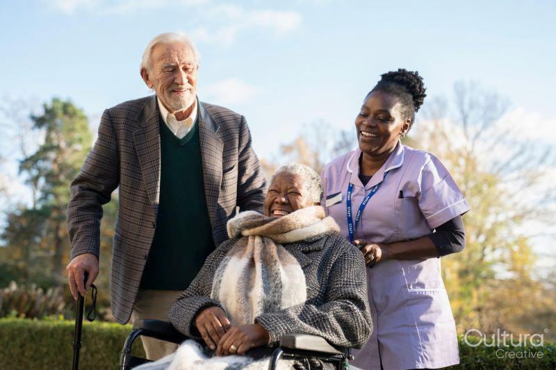 Senior people accompanied by nurse going on walk in park