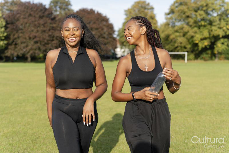 Young female friends walking in park after exercising