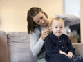 Mother helping daughter with hearing aid